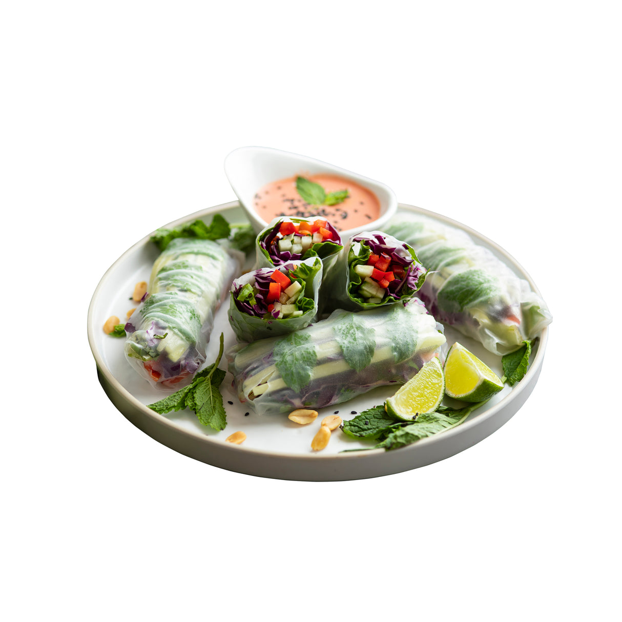 A white melamine serving tray displays fresh vegetable spring rolls—some cut to reveal colorful fillings like carrots, cucumber, and lettuce. Lime wedges, mint leaves, peanuts, and a pink dipping sauce add flair. The durable tray is dishwasher safe.