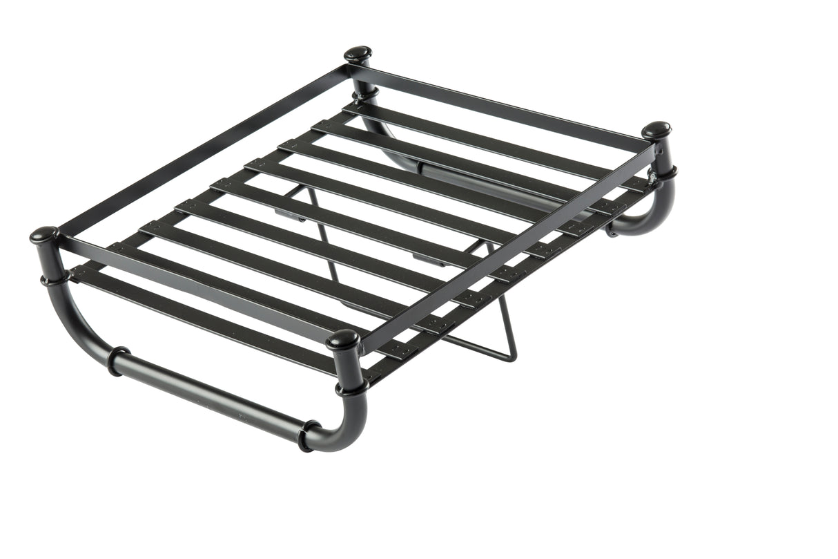 A black metal luggage rack with horizontal slats and sturdy cylindrical legs, part of the industrial collection. Designed to hold suitcases or bags, it features a lower support bar and folded legs, set against a plain white background.