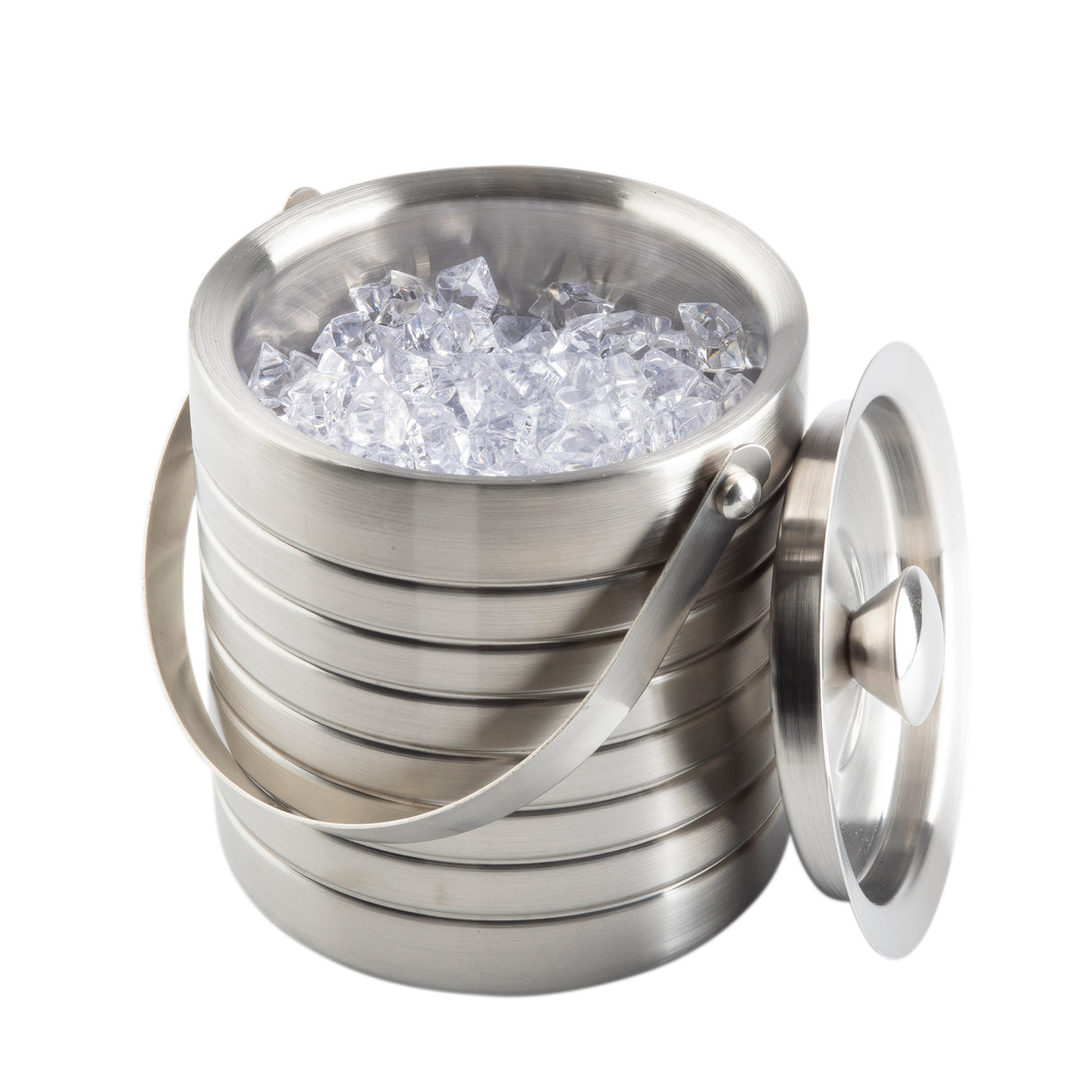 A round TableCraft ice bucket, crafted from stainless steel with a horizontal groove design, is filled with clear ice cubes. Its handle is raised, while the matching lid rests to the side against the bucket, all set against a white background.