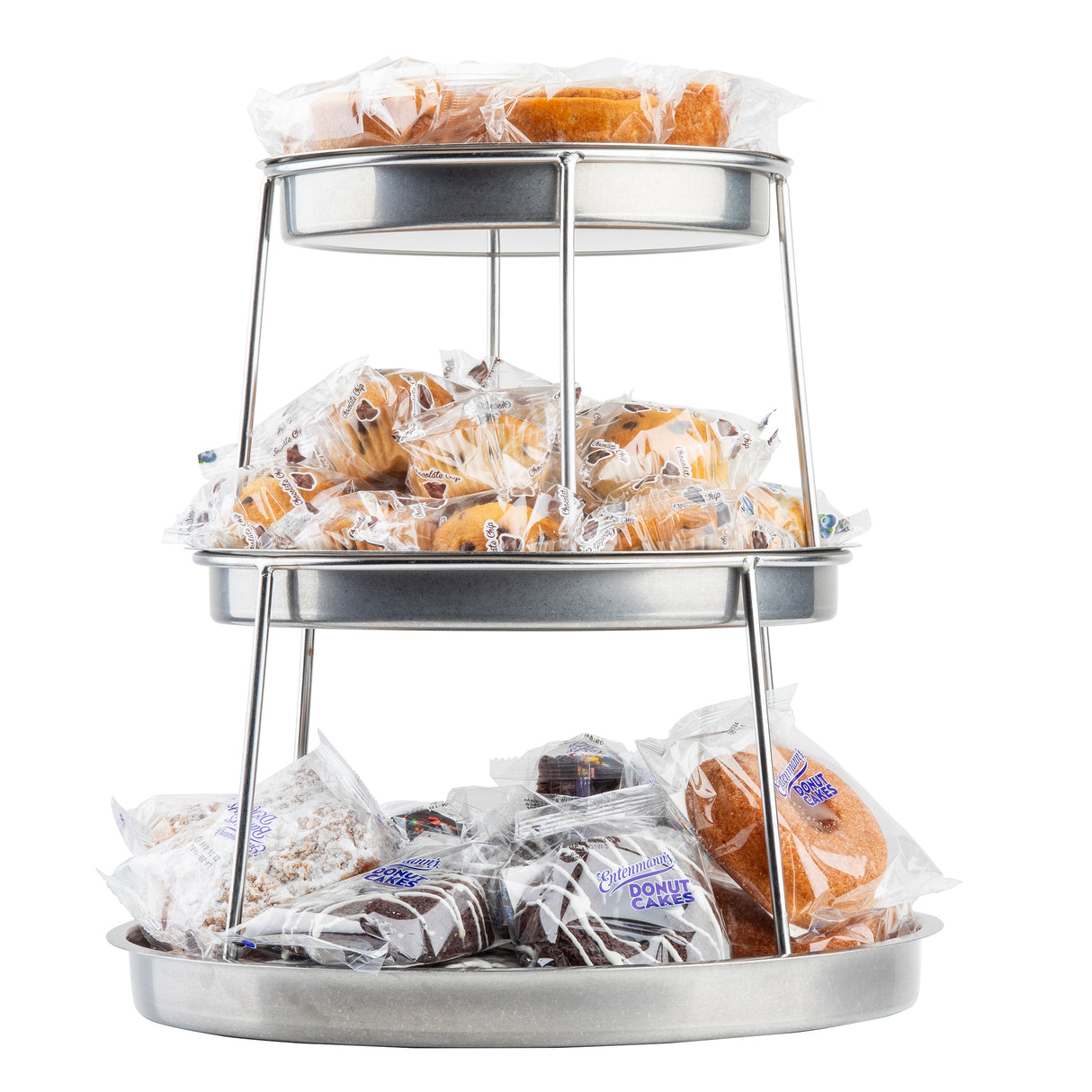 A 3-tier stainless steel sharing tower holds various individually wrapped pastries like donuts, cakes, and muffins. Each shelf displays an assortment in clear packaging with visible labels, all neatly arranged against a white background.