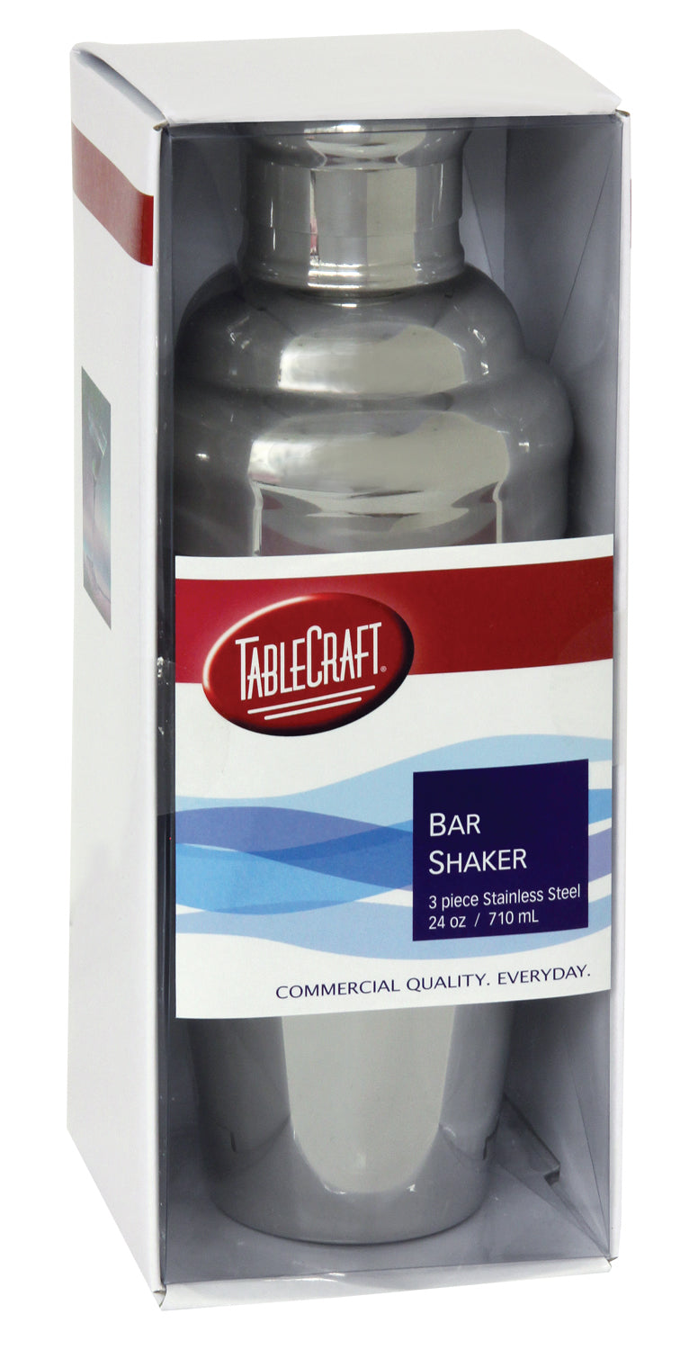 A stainless steel TableCraft bar shaker set, 24 oz (710 mL), is displayed in a clear plastic box with a red, white, and blue label stating it is a 3-piece stainless steel shaker. The slogan at the bottom reads “COMMERCIAL QUALITY. EVERYDAY.”.