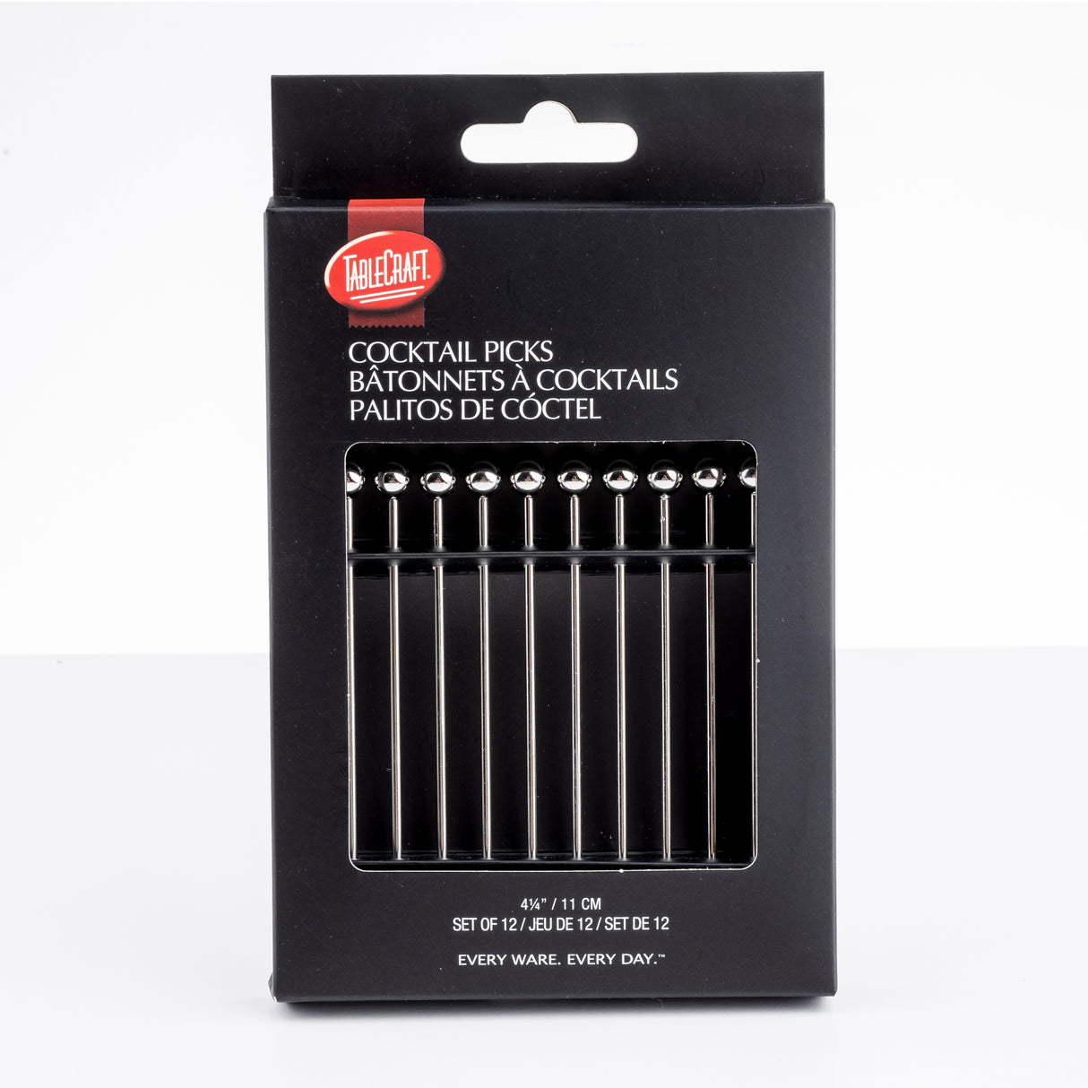 A black box of TableCraft cocktail picks is shown upright. The packaging has a clear window displaying 12 stainless steel picks with round ball tops. The text on the box appears in English, French, and Spanish, with product size and quantity details.