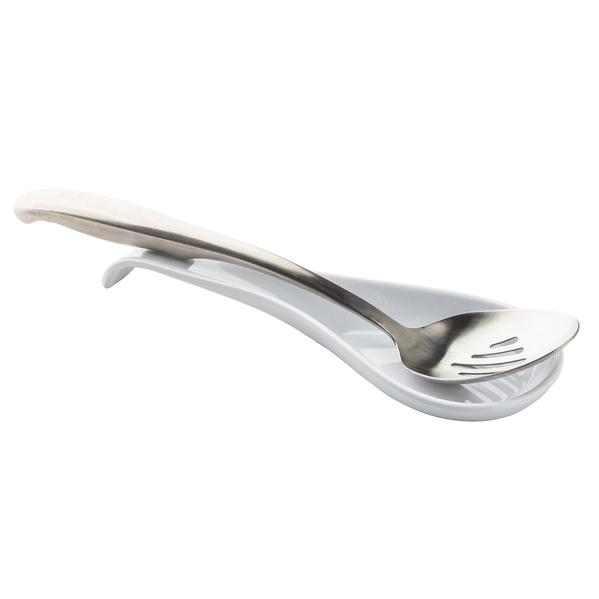 A metal slotted spoon rests on a white, curved TableCraft melamine spoon rest. The spoon has a simple, smooth handle and sits securely in the center of the rest, which features raised ridges to catch drips. The background is plain white.
