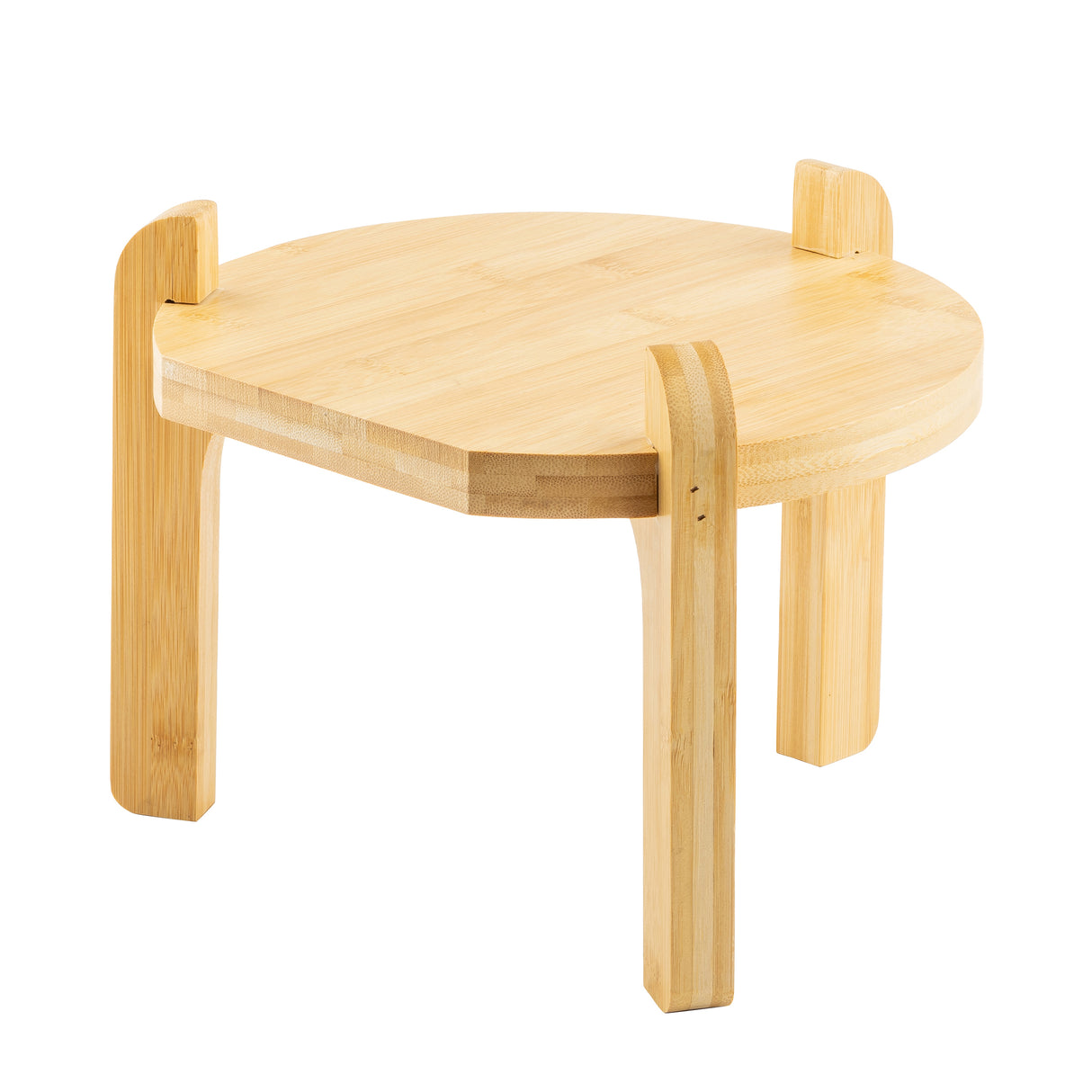 A small, round bamboo table with three thick, angled legs serves as a stylish beverage dispenser stand. The TableCraft-inspired design features smooth edges, light wood finish, and minimalist charm, with legs forming short vertical tabs above the tabletop.