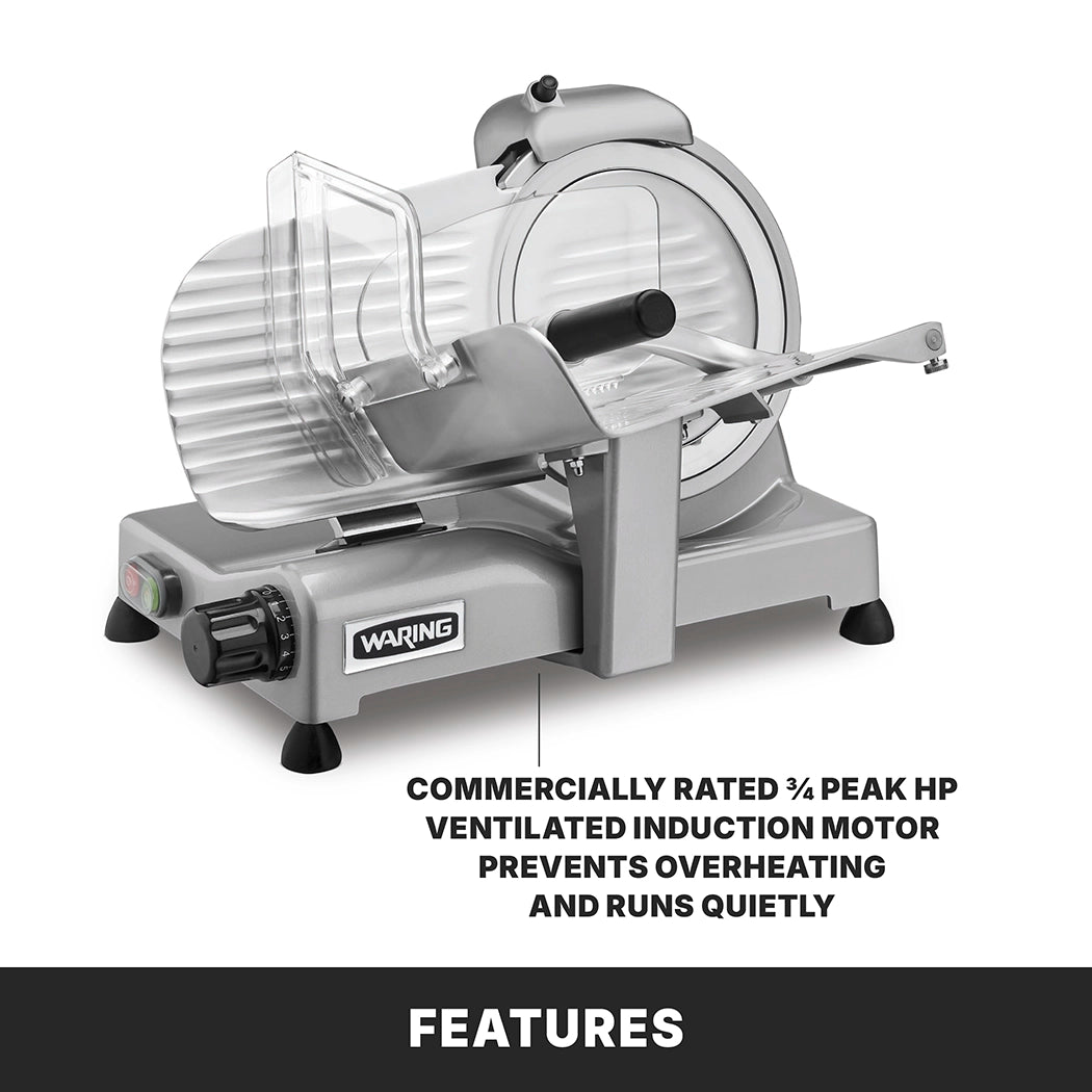 A Waring Commercial Food Slicer sits on a gray surface, featuring a clear guard and adjustable slice thickness knob. This electric food slicer’s ¾ peak HP ventilated induction motor prevents overheating and ensures quiet operation.