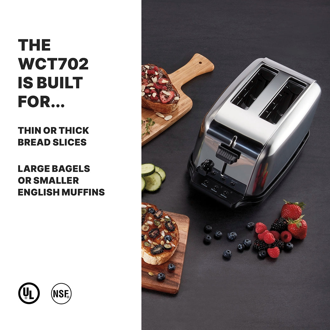 A stainless steel toaster with browning controls and extra-high lift sits on a dark countertop next to wooden boards with toasted bagels topped with fruit and cream cheese. Text describes its versatility for bread, bagels, and muffins.
