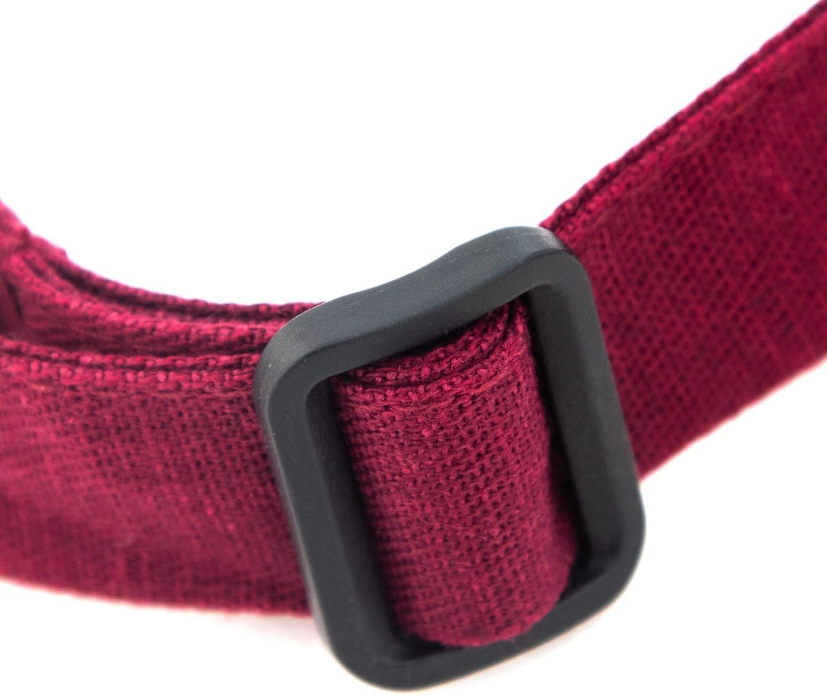 Close-up of a textured maroon fabric strap with a black rectangular plastic buckle, part of an adjustable neck bib apron. The woven material and clean stitching stand out against the plain white background, creating strong contrast.