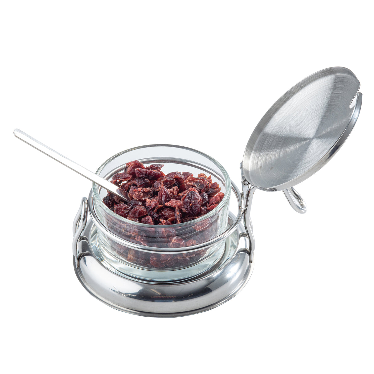 A glass container filled with dried cranberries sits in a shiny silver metal holder. The holder has a round base, an open hinged lid, and a small silver spoon inside. This stylish condiment jar set is perfect for the table and is dishwasher safe.