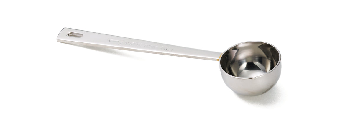 A shiny, dishwasher safe stainless steel coffee scoop with a long handle lies on a white background. The handle has a small hole at the end for hanging, and the deep, round bowl is perfect for measuring coffee grounds.