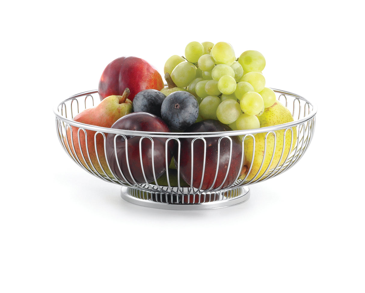 A chrome plated TableCraft chalet basket filled with apples, pears, plums, nectarines, green grapes, and blueberries sits on a white background. The fruits are fresh and colorful within the basket’s evenly spaced curved metal bars.