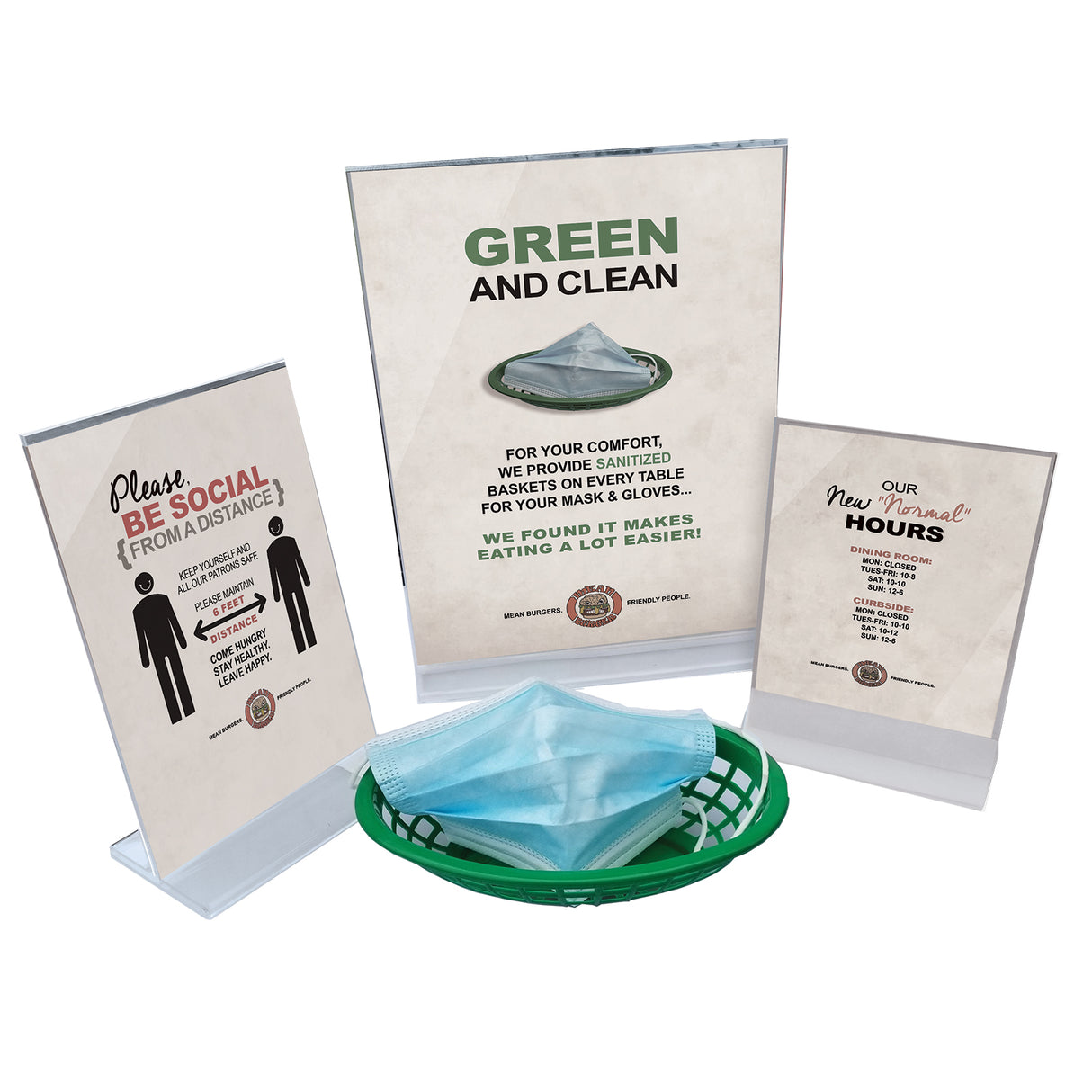 A display with three informational signs in an acrylic menu holder and a green basket of blue disposable face masks. The signs share tips on social distancing, cleanliness, and business hours, encouraging safe practices in a public setting.