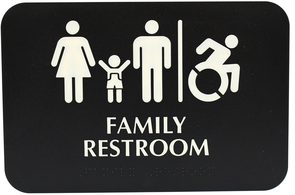 A black restroom sign with white icons of a woman, child, man, and wheelchair user separated by a line. Bold text reads FAMILY RESTROOM with ADA compliant Braille below, indicating the space is handicap accessible.
