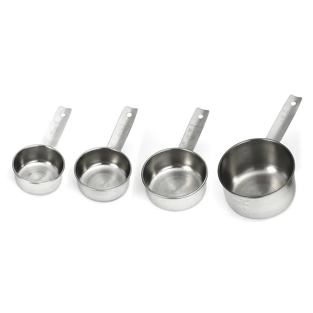 Four stainless steel measuring cups of different sizes are arranged in a row from smallest to largest. Each dishwasher safe cup has a flat handle with a hole at the end, and engraved measurement markings, set against a white background.
