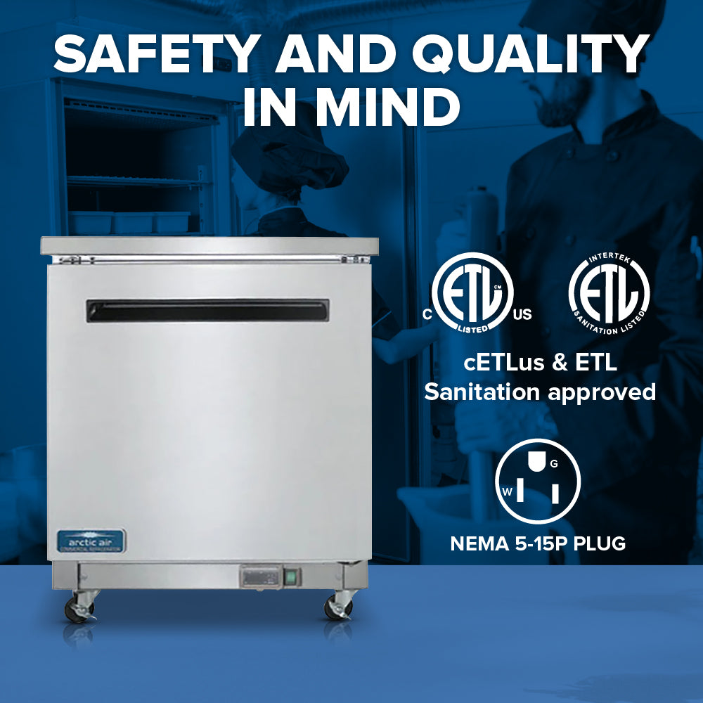 A commercial Arctic Air AUC27F reach-in freezer on wheels sits in a professional kitchen with chefs working in the background. Bold text at the top reads SAFETY AND QUALITY IN MIND, highlighting cETLus & ETL sanitation approvals and NEMA 5-15P plug.