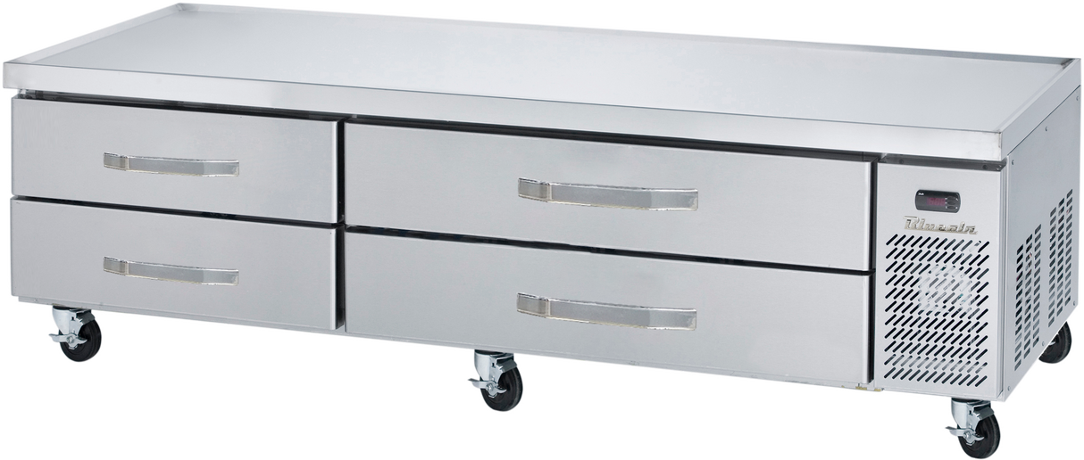 A stainless steel refrigerated chef base with four horizontal drawers and a right-side ventilation panel sits on caster wheels. The flat surface is ideal for prepping food, making it a versatile equipment stand in restaurant kitchens.
