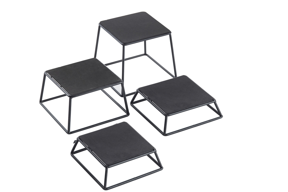 Four black powder coated metal risers of varying heights are arranged on a white background. This minimalist TableCraft Products riser set features flat tops and angled legs, perfect for modern display or organization.