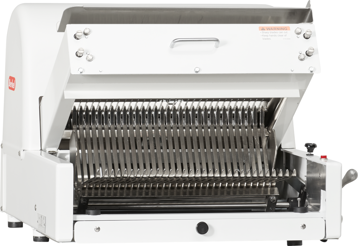 A countertop Bread Slicer with a white exterior and open front reveals sharp, parallel blades for slicing loaves. Featuring two silver handles on the upper edge, the Berkel MB1/2STD has a “WARNING” label near the top right corner.