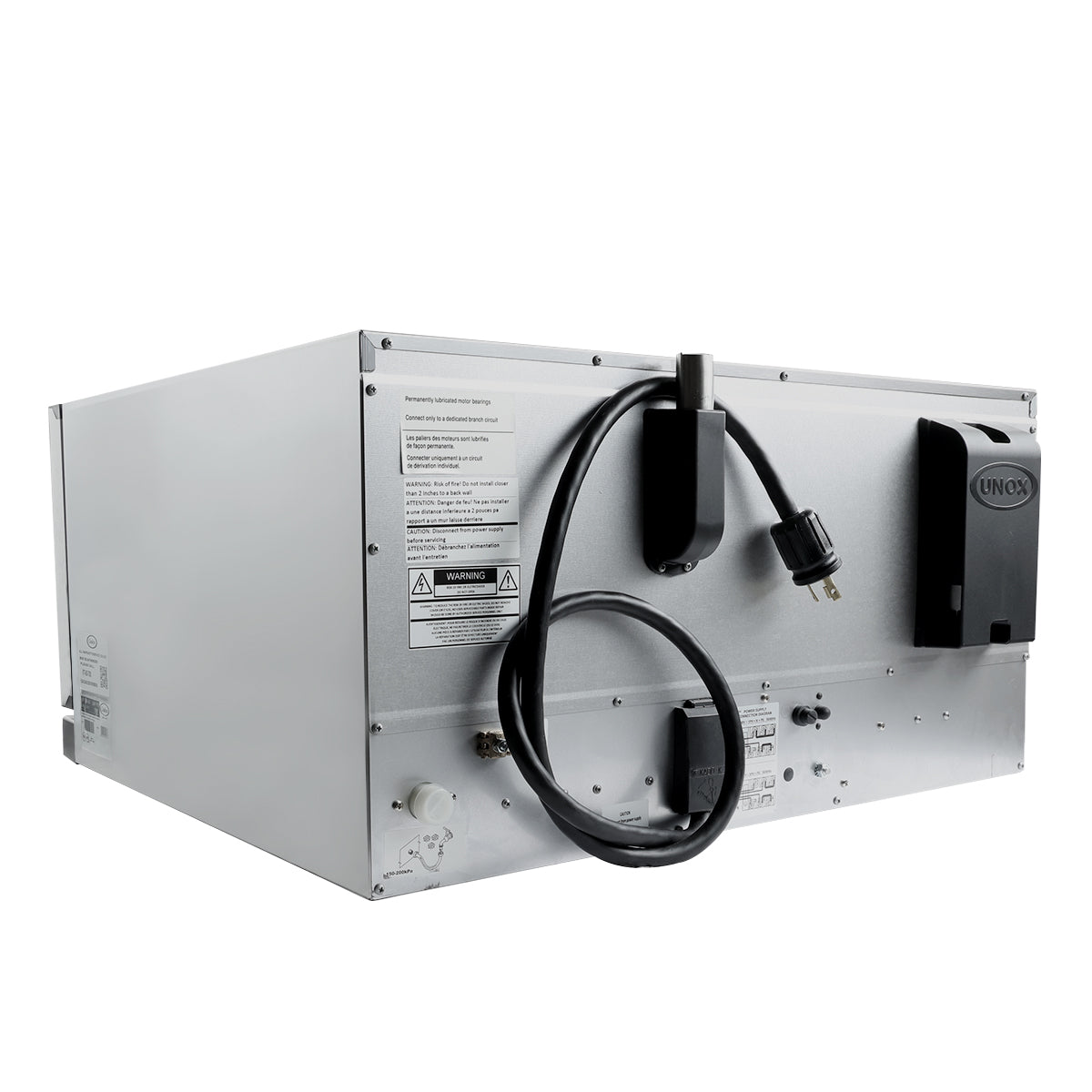 A large silver industrial convection oven is shown from the back. It features a black power cord, manufacturer labels, warning stickers, and vented panels on its metal casing, with various screws, a control knob, and a black device mounted on the right.