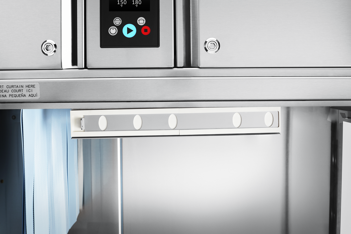 Close-up of a stainless steel conveyor dishwasher with a digital display showing numbers and control buttons. Below the display is a metallic panel with round magnets, while the interior—designed for automatic soil removal—appears clean and industrial.