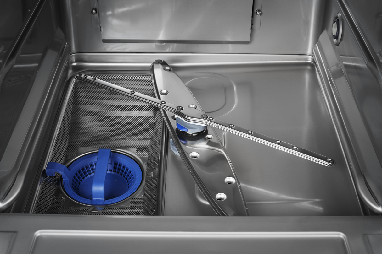 Close-up view of the inside bottom of an ENERGY STAR undercounter dishwasher, showcasing a metal spray arm, round blue filter, mesh filter screen, and high temperature sanitizing mechanisms. The clean stainless steel surfaces reflect light.