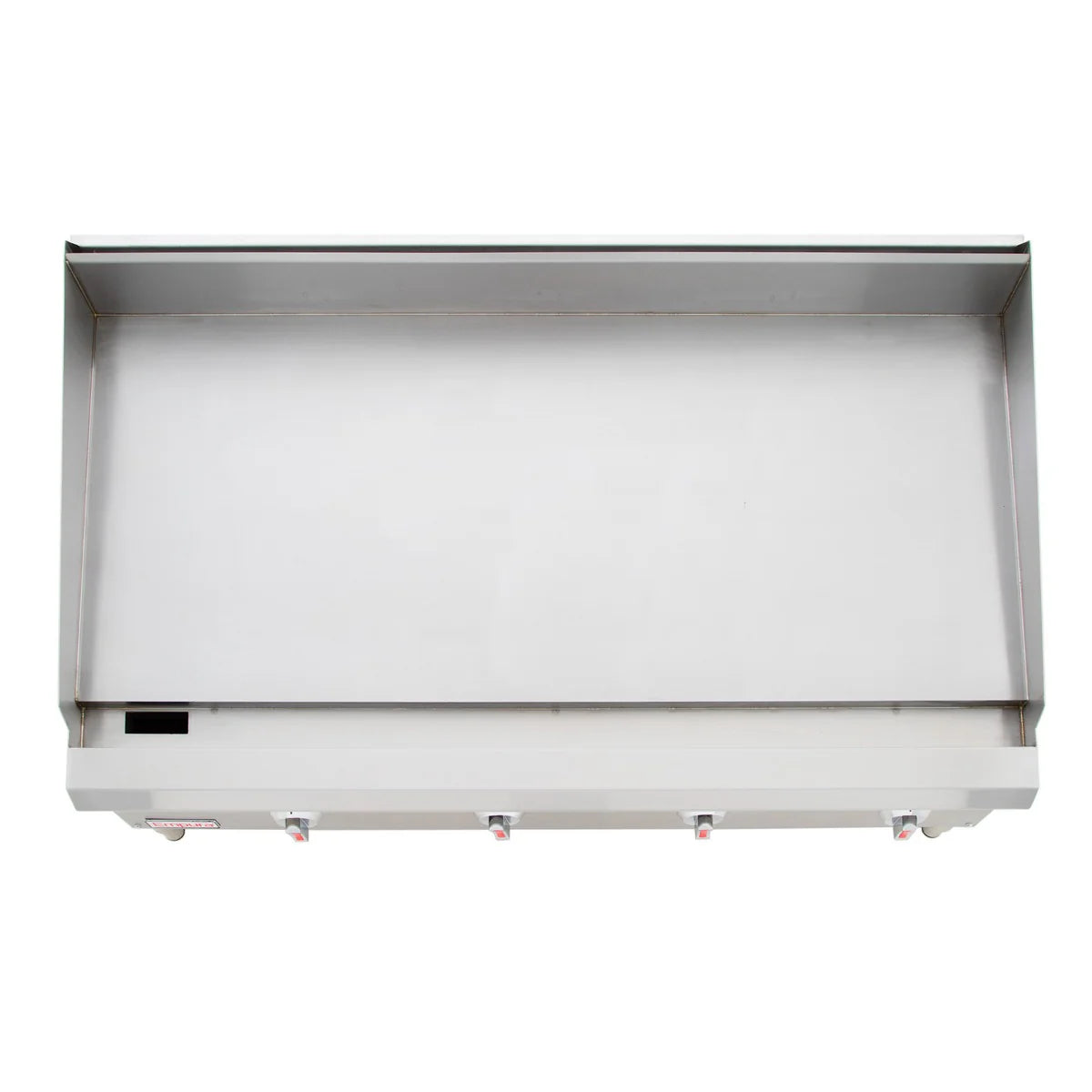 A top-down view of a large, rectangular stainless steel countertop griddle with raised edges and four control knobs along the front panel. The heavy duty gas griddle surface appears clean and unused, with a small rectangular opening on the left edge.
