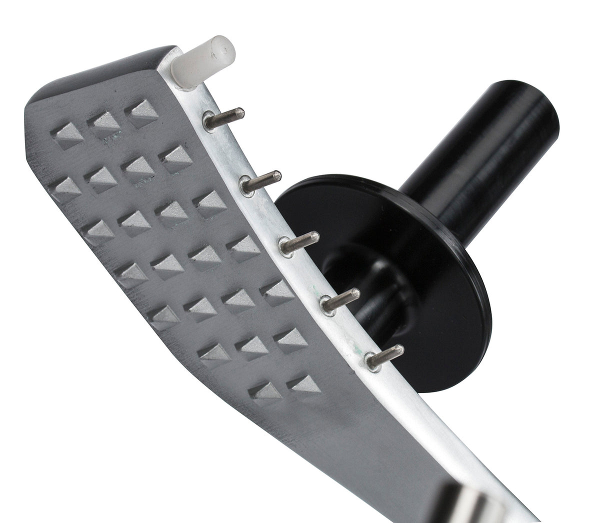 Close-up of a metal meat tenderizer with a textured, diamond-shaped surface and short metal spikes, positioned beside a manual slicer. It features a white plastic peg, black cylindrical handle, and round guard against a plain white background.