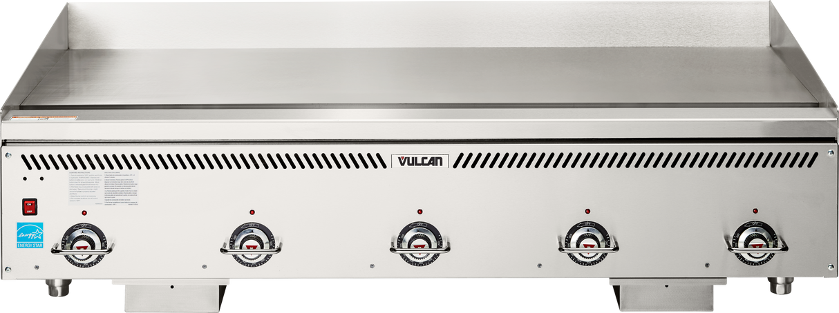 A large stainless steel Heavy Duty Griddle with four control knobs and indicator lights on the front panel. The spacious flat surface is ideal for cooking multiple foods, and Vulcan’s name is centered above the controls on this countertop gas griddle.
