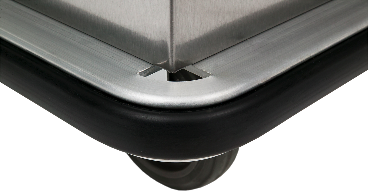 Close-up of a mobile food cabinet corner with a protective black rubber bumper. The rounded edge and partially visible gray wheel showcase the cart’s sturdy construction and protective features, ideal for transporting food safely.