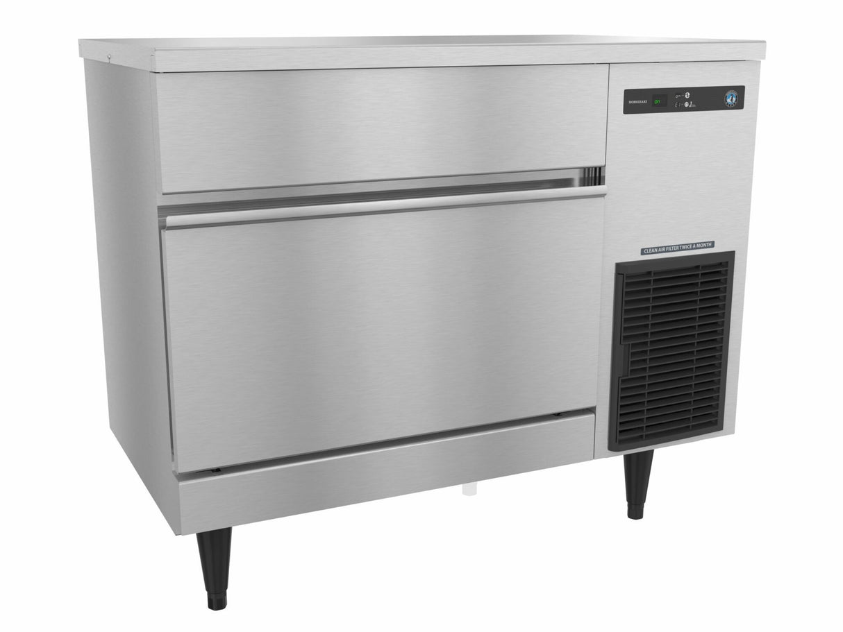 A commercial Hoshizaki stainless steel ice storage bin with black adjustable legs, a horizontal handle, and a digital control panel on the upper right. This undercounter ice maker features a smooth, reflective surface and a vent below the control panel.