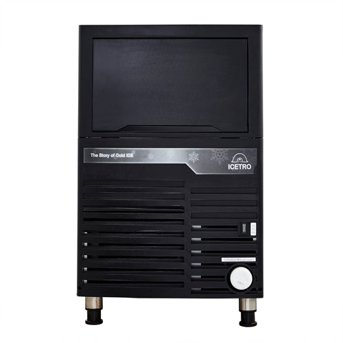 A black commercial cube-style ice maker with a rectangular body, silver legs, and a front panel featuring ventilation slats, buttons, a dial, and labels. The upper section displays the Icetro logo and the text The Story of Cold ICE.
