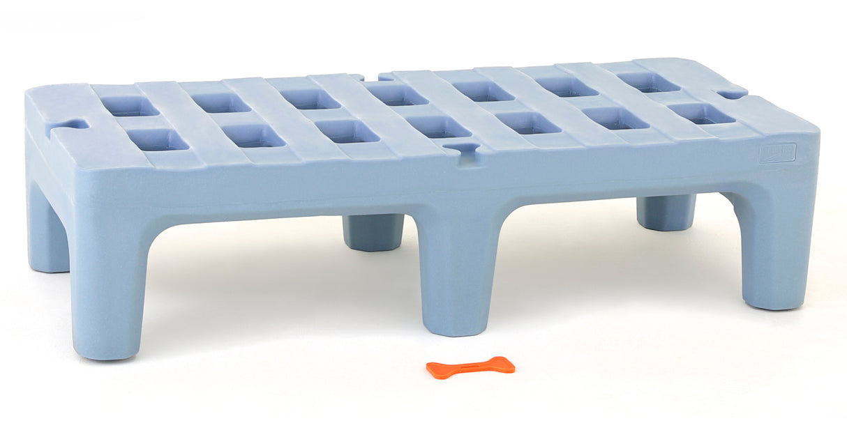 A light blue Dunnage Rack made from rust proof polymer with grid-like square openings sits on six short legs. In front of it, on a white surface, lies a small orange bone-shaped object. The overall setting is minimalist and brightly lit.