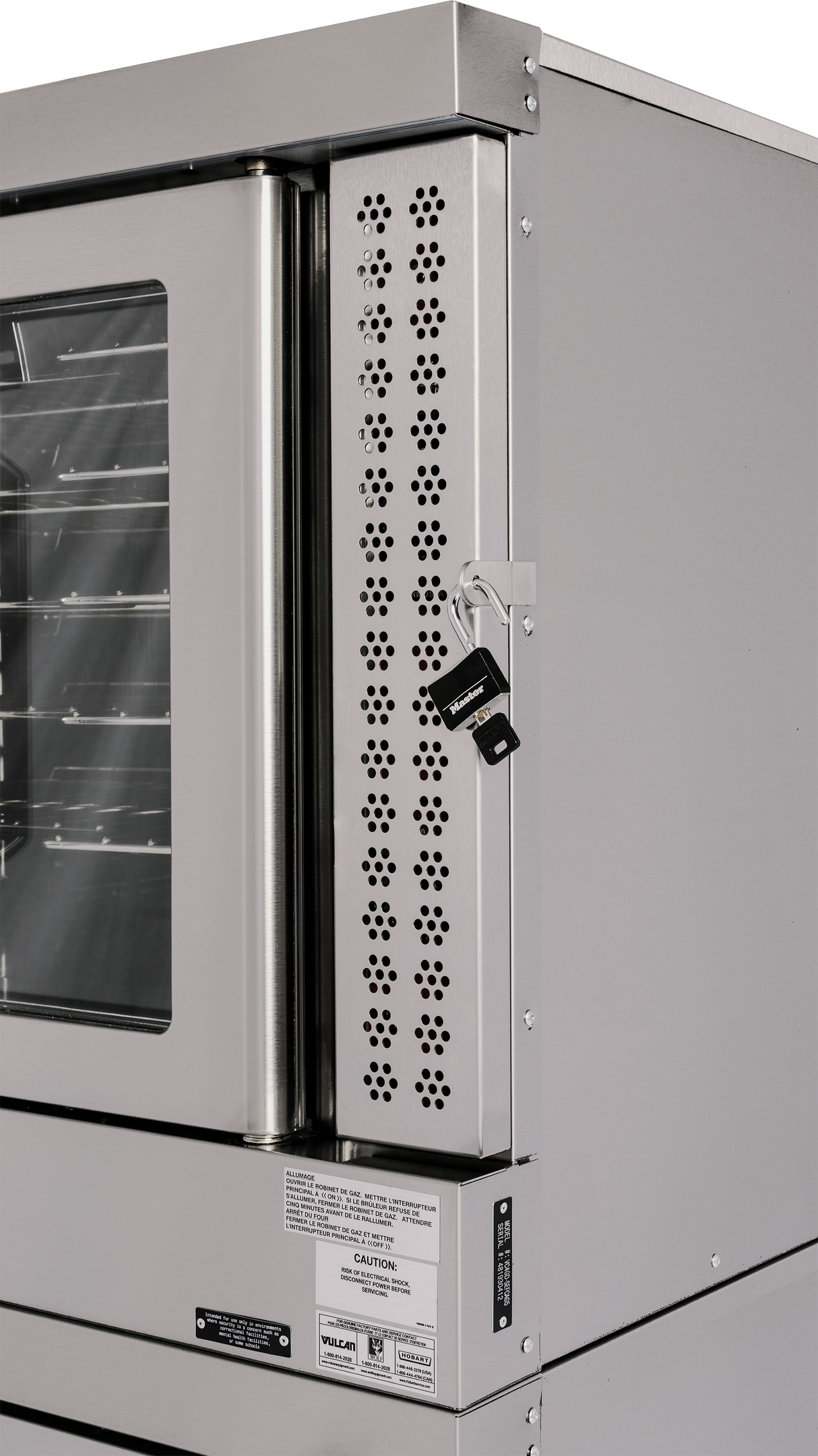 Close-up of a stainless steel commercial convection oven with a glass window on the door. This double-deck oven features a vented metal panel with keyhole, two keys hanging from a lock, and various caution and product labels below the panel.