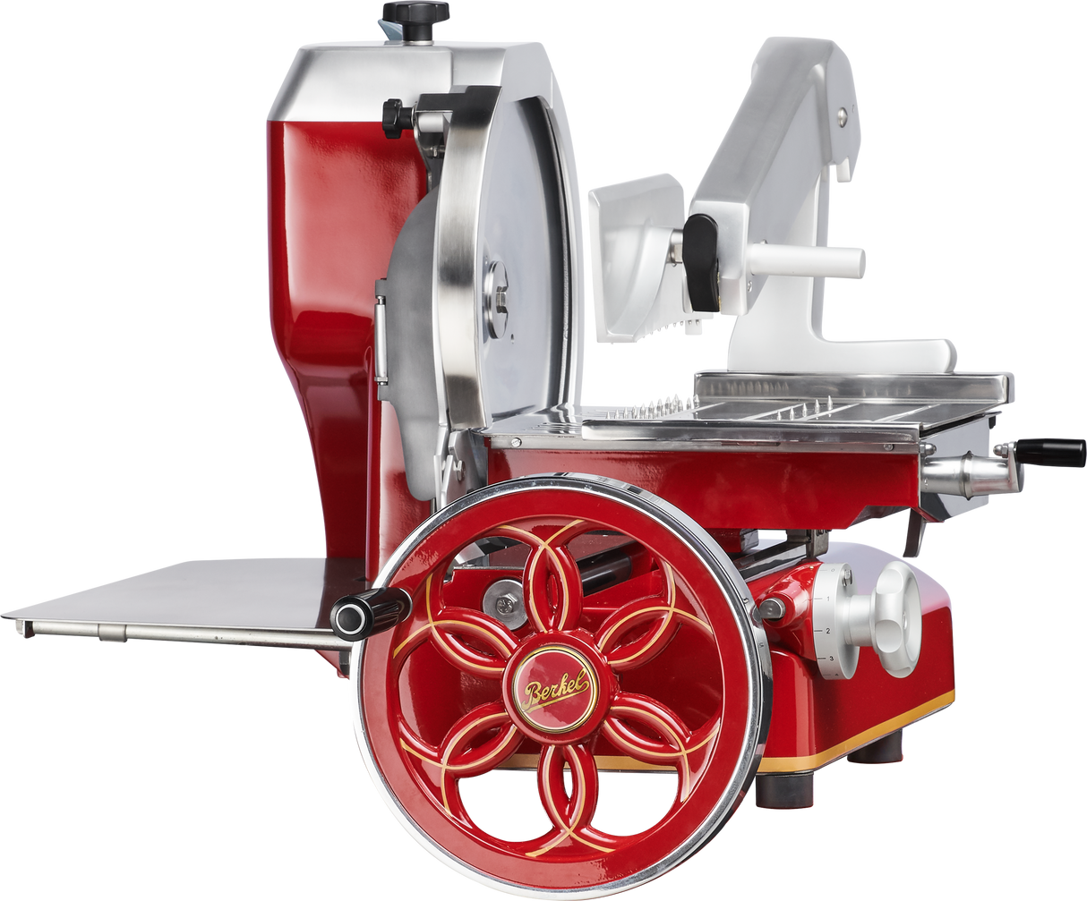 A red and silver vintage-style Berkel 330M Fly Wheel Slicer with a large decorative hand crank, Chromium-plated Carbon Steel Knife, shiny blade, stainless steel tray, and white handle components, viewed from the side.