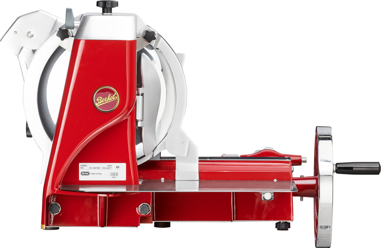 A vintage-style red and white Fly Wheel Slicer with a large Chromium-plated Carbon Steel Knife, shiny metal handle, and the Berkel logo on the side. The Berkel 330M rests on a flat surface and features an adjustable guide for slicing thickness.