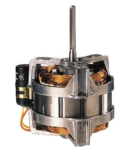 A close-up of an electric motor from a combination food processor, with a vertical metal shaft, exposed copper coils, and metallic housing. Wires and a black cylindrical capacitor are attached on the left side, revealing internal components.