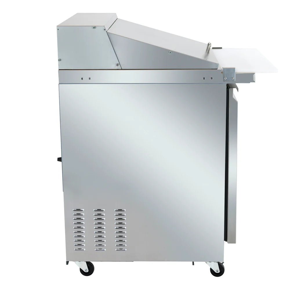 A commercial stainless steel mega top prep table with wheels, side view. It features a work surface with a raised back, a flip-up lid on top—ideal for a refrigerated sandwich prep table—and a white cutting board extending from the right side.