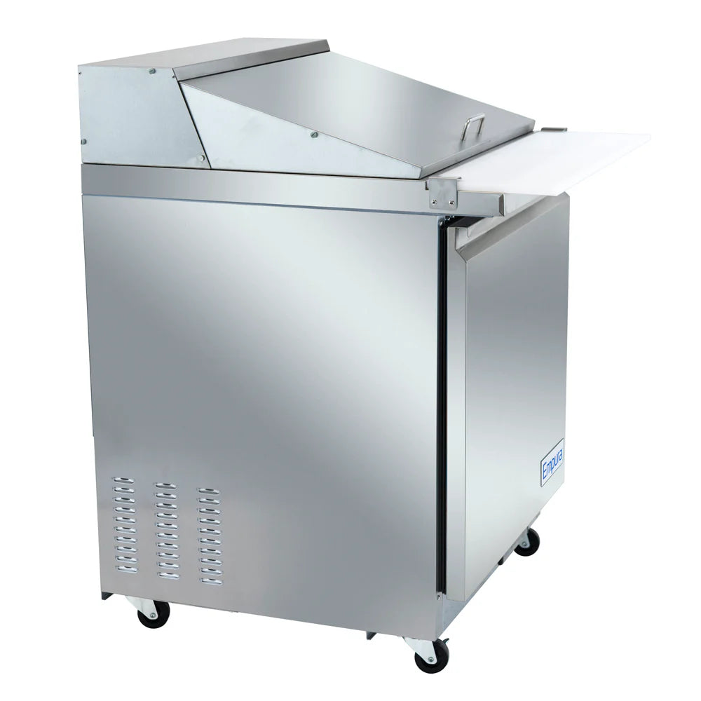 This Empura refrigeration mega top prep table features a commercial stainless steel build with a closed, angled lid, front door, lower vent holes, and four casters. Its white cutting board extends from the front for efficient sandwich prep.