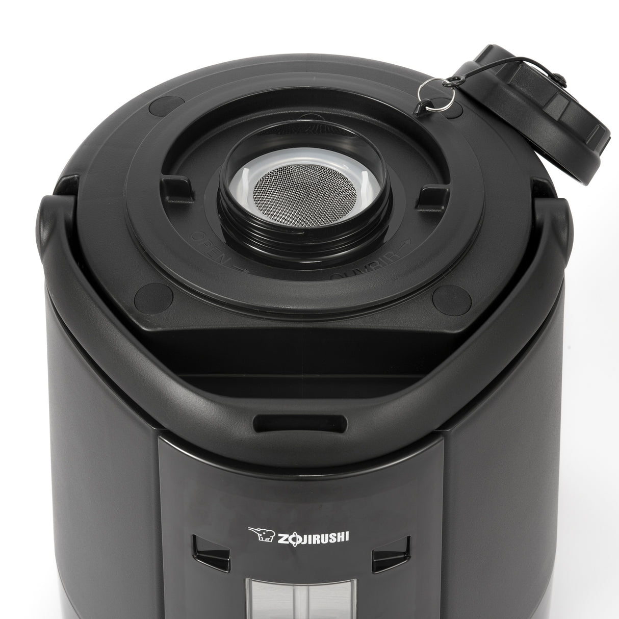 A close-up of a black Zojirushi insulated beverage dispenser shows the open lid, revealing a metal mesh filter inside the round opening. The glossy exterior features a visible logo and water level window on the front panel.