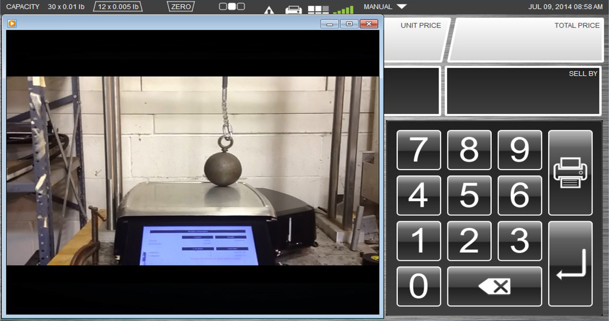 A metal ball hangs by a chain above an electronic scale with a 7 customer display. Beside the image is a keypad with large numbers and labeled buttons, resembling an advanced weighing system interface.