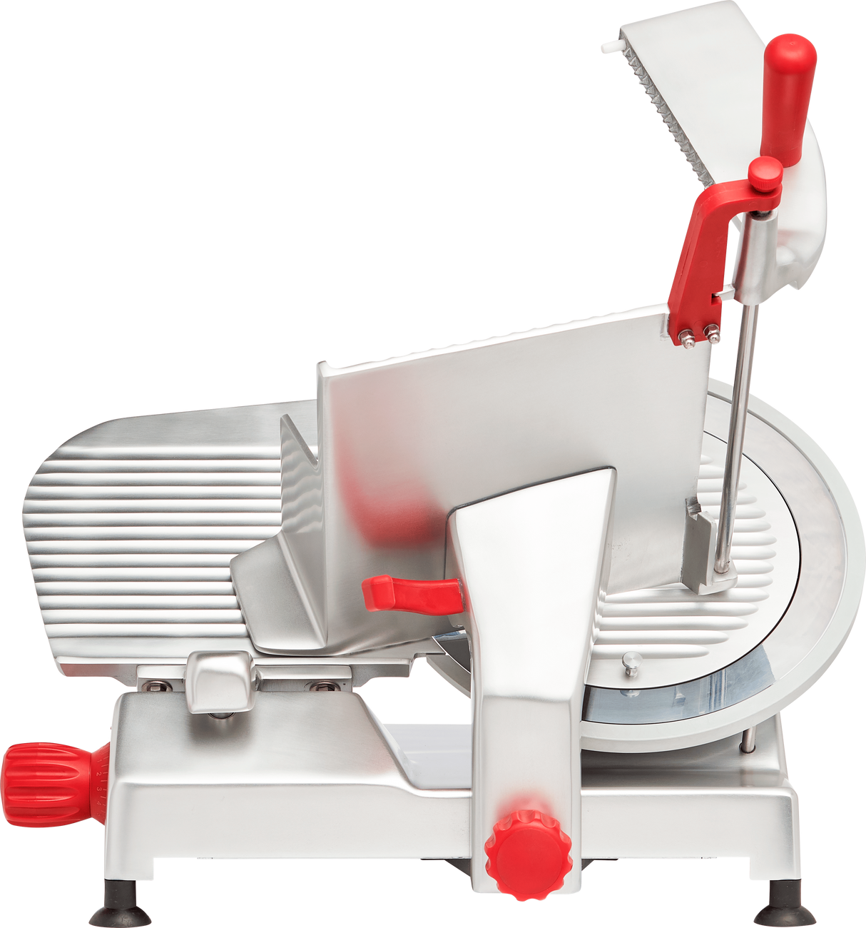 A silver and red manual gravity feed slicer with a large carbon steel knife blade, ridged sliding tray, red knobs and handles, and a safety guard, photographed from the side on a white background.
