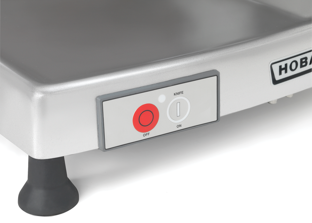 Close-up of a Heavy Duty Meat Slicer control panel, featuring red OFF and gray ON buttons labeled KNIFE. The appliance, likely a Hobart HS6N-1R, has black feet and part of the brand name visible near its 13 CleanCut knife.