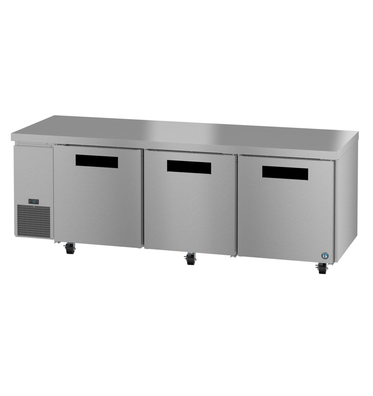A long stainless steel undercounter refrigerator with three black-handled doors, mounted on small wheels. The unit has a flat top surface and a vent on the lower left side, ideal for professional kitchens or food service settings.