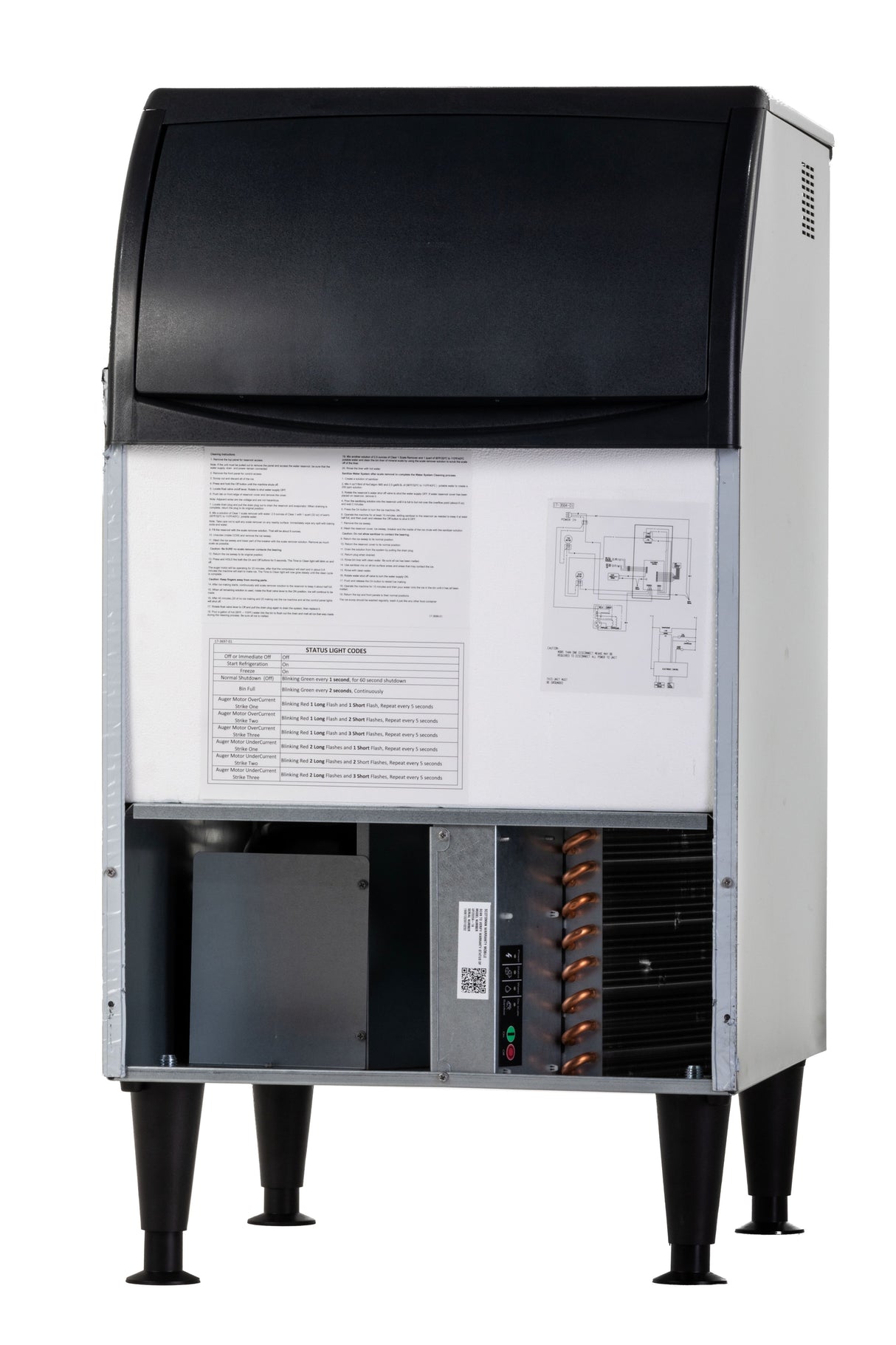 A commercial undercounter ice maker with a black top and white body is shown on black legs. The front panel is open, revealing technical instructions, a diagram, and internal components like copper coils and wiring. The unit stands on a white background.