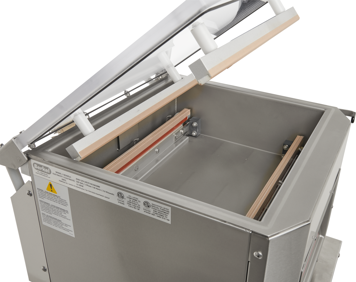 The Berkel 350D-STD Single Chamber Vacuum Packaging Machine features a stainless steel build, an open transparent lid revealing a spacious rectangular chamber, heating bars, sealing components inside, and visible safety and specification labels on the exterior.