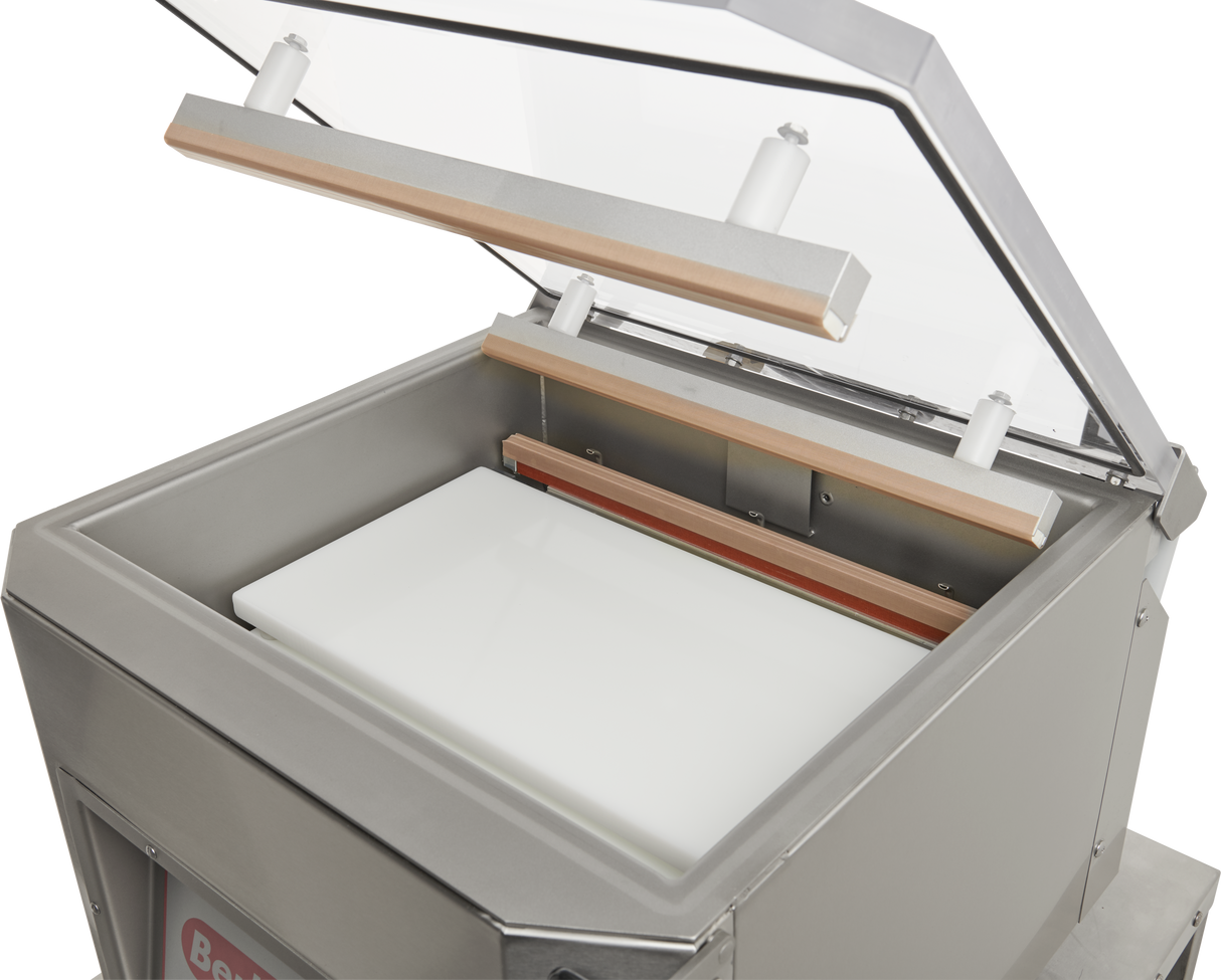 A close-up of a single chamber Vacuum Packaging Machine with its transparent lid open, revealing the sealing bars and a white rectangular insert inside the stainless steel chamber. The machine features a clean, modern design.