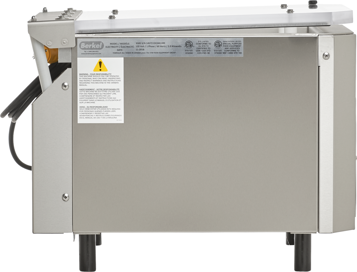 A stainless steel Berkel 350D-STD food slicer viewed from the side, showing a rectangular metal body with labels and warnings. The machine has a black power cord, four black legs, a plastic safety guard, and a white top tray or panel.