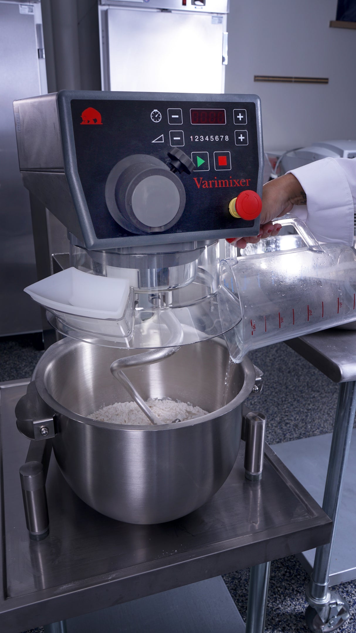 A person using a Varimixer KODIAK 20 qt. food mixer.