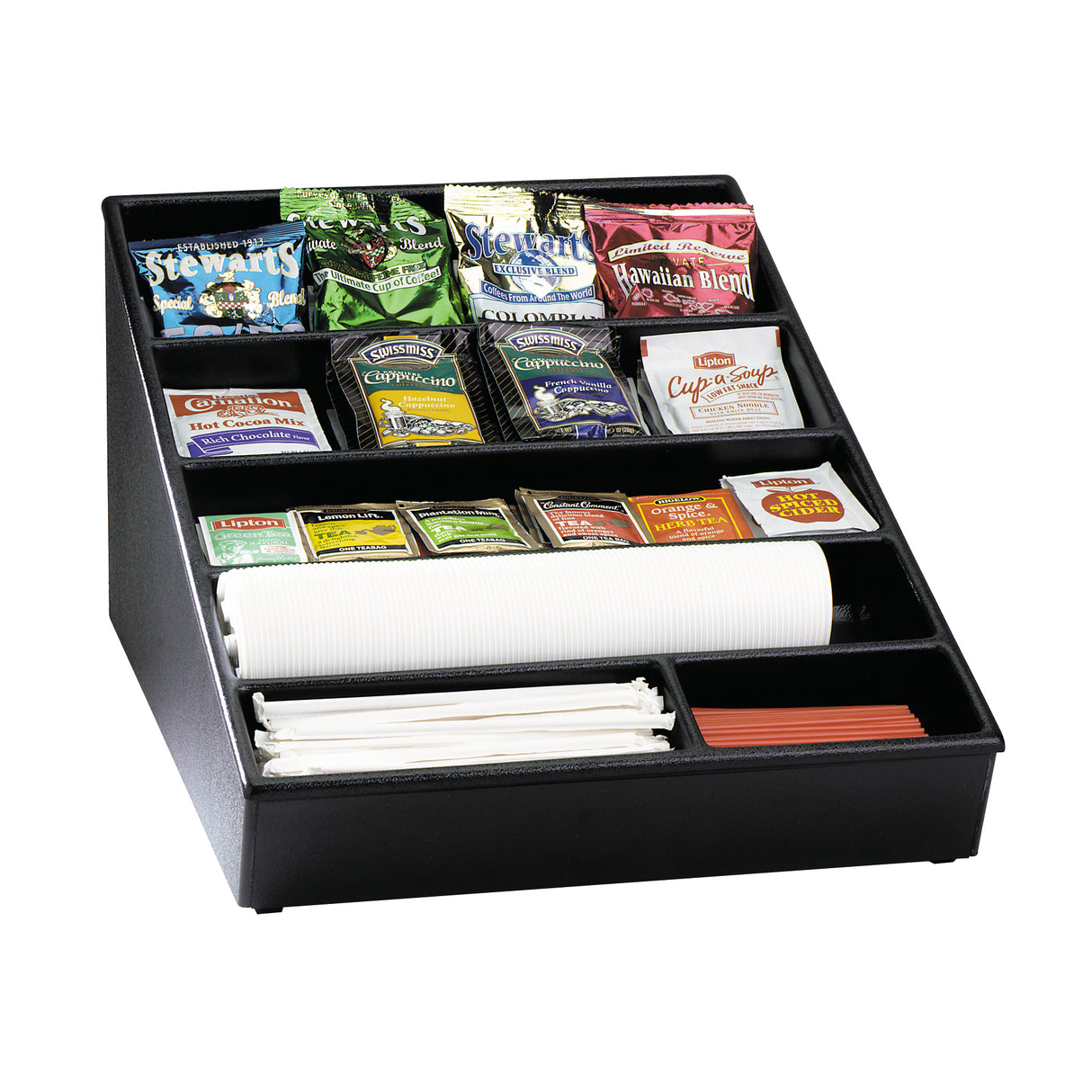 Black countertop condiment organizer with compartments holding assorted tea and coffee packets, sugar and creamer packets, stir sticks, white disposable cups stacked horizontally, and red coffee stirrers. The organizer is angled for easy access.