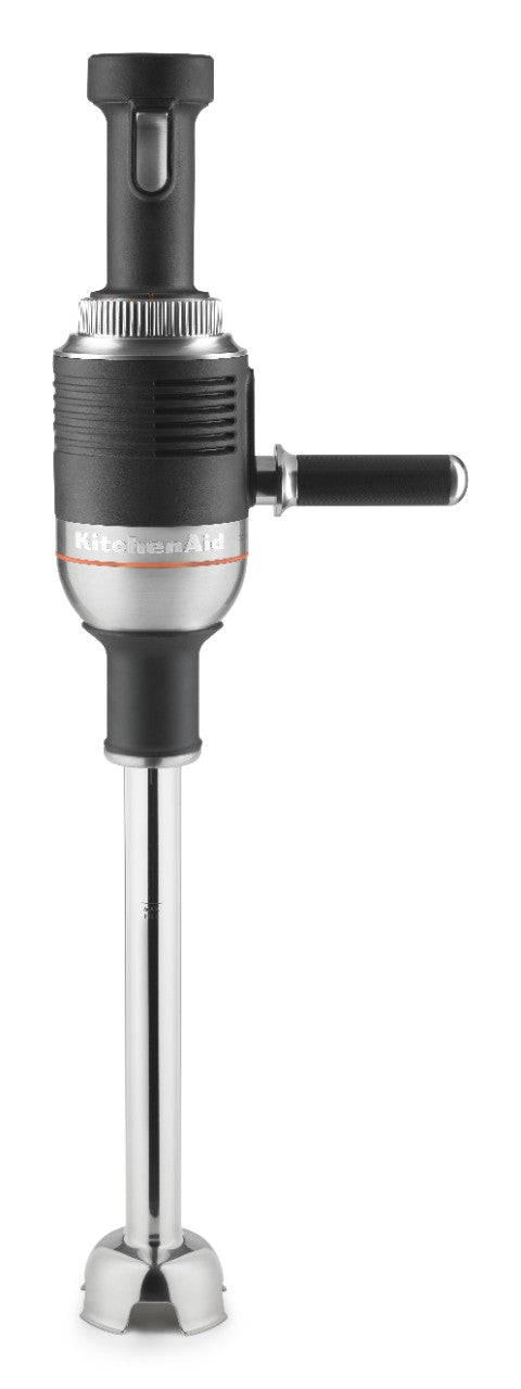 A black and silver KitchenAid immersion blender stands upright, featuring a long stainless steel blending shaft and a black handle protruding from the side. The top section has a textured grip and visible control dial, highlighting its commercial immersion blender design.