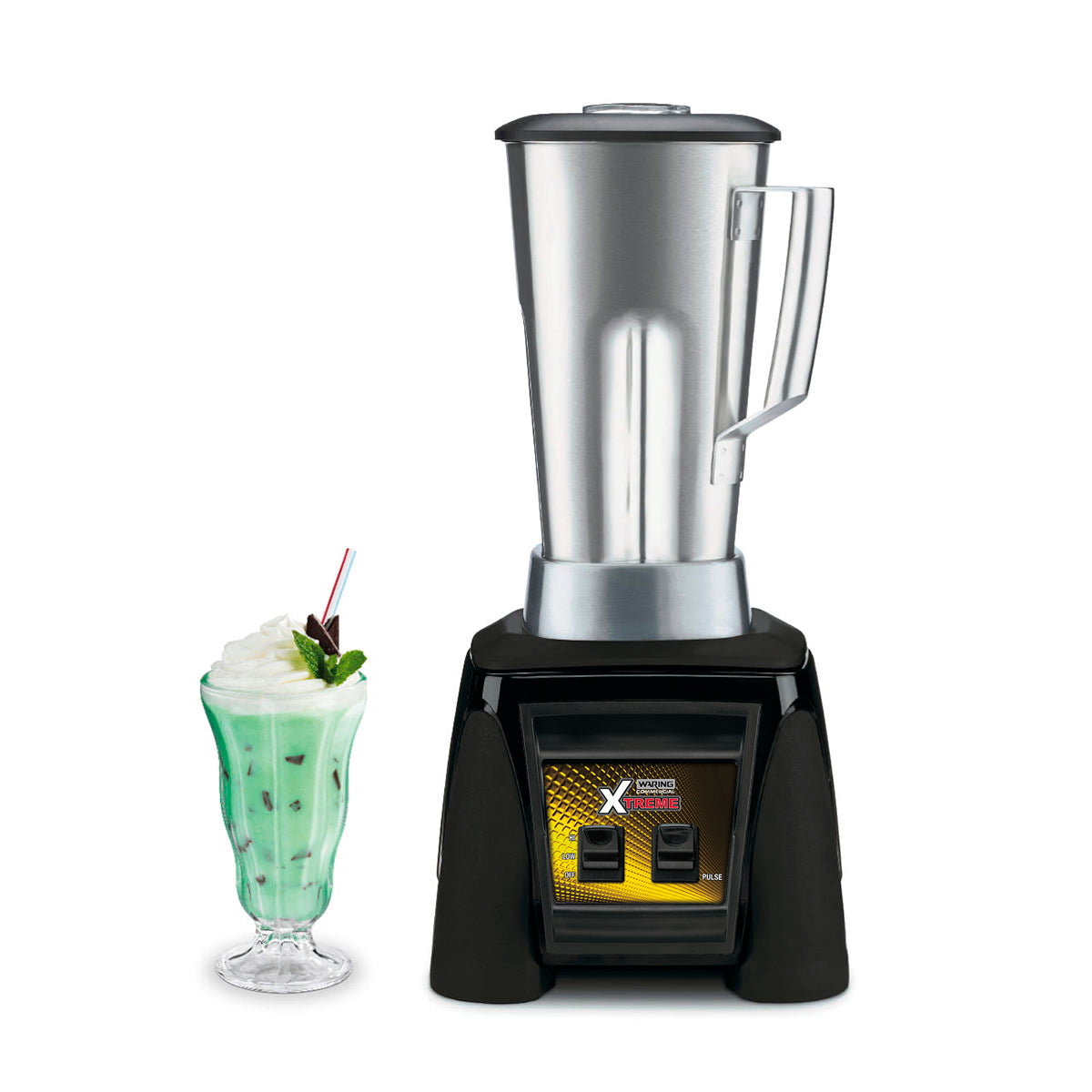 A high-power blender with a stainless steel container and black and yellow base stands on a white background. Next to it is a tall glass filled with green milkshake, topped with whipped cream, a red-striped straw, cherry, and mint sprig.